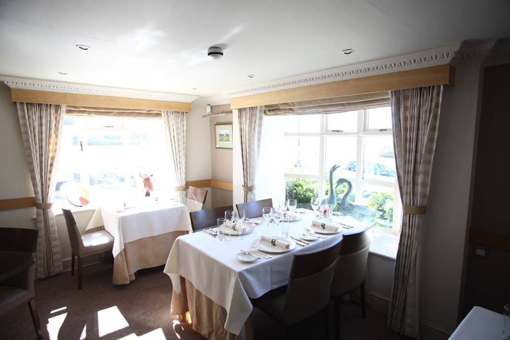A dressed table for two in the dining room at 36 On The Quay, overlooking Emsworth harbour