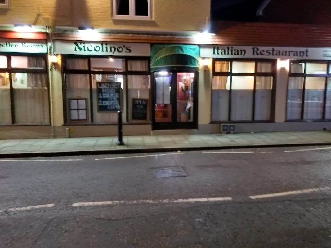 The shopfront of Nicolino’s Italian Restaurant on North Street, Emsworth, lit up at night